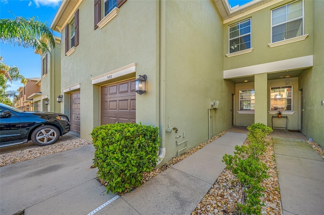 property entrance featuring a garage and stucco siding