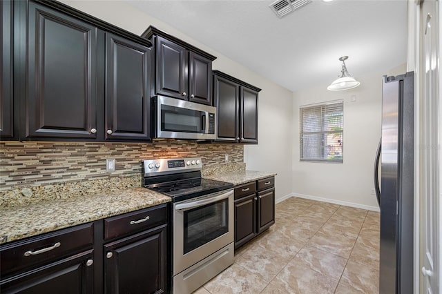 kitchen with visible vents, decorative backsplash, appliances with stainless steel finishes, light stone countertops, and baseboards