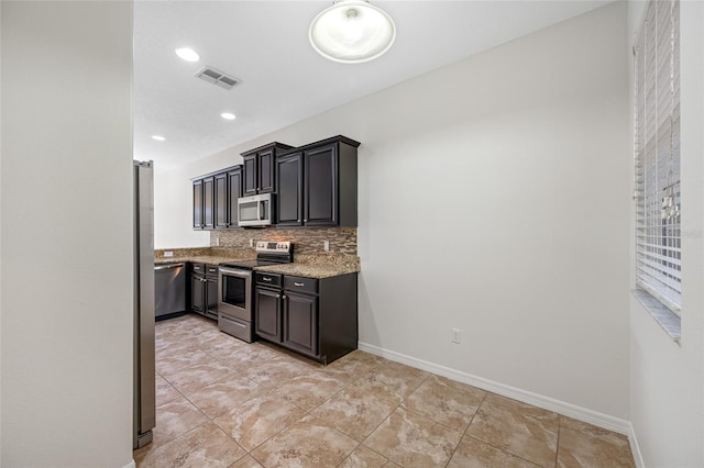 kitchen with baseboards, visible vents, appliances with stainless steel finishes, and backsplash