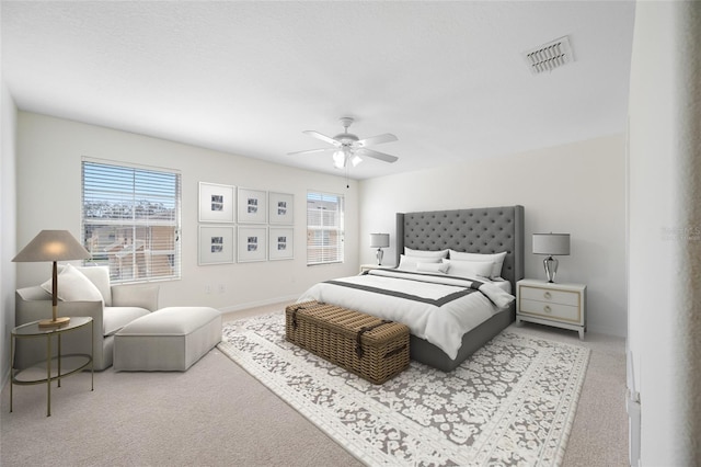 carpeted bedroom featuring a ceiling fan, visible vents, baseboards, and multiple windows