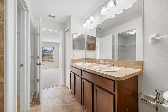 full bathroom with tile patterned floors, visible vents, a sink, and double vanity