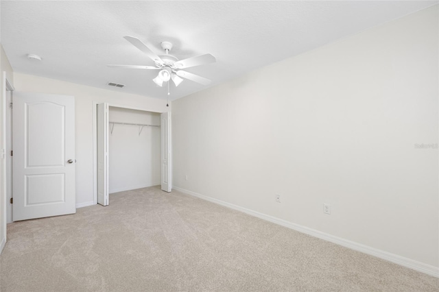 unfurnished bedroom featuring ceiling fan, baseboards, a closet, and light colored carpet