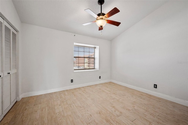 unfurnished bedroom featuring a ceiling fan, a closet, baseboards, and wood finished floors