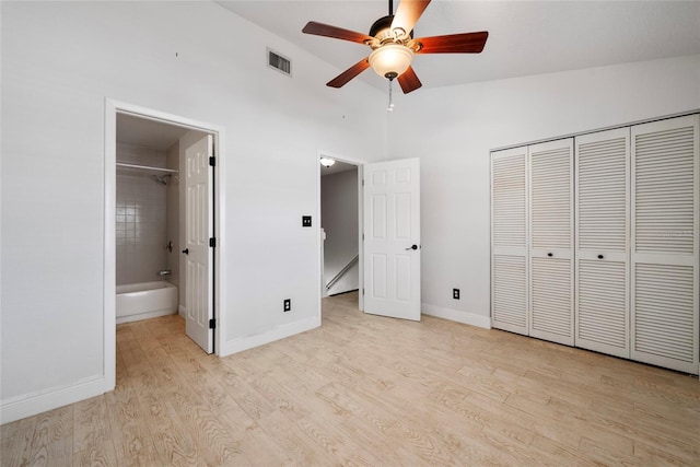 unfurnished bedroom featuring lofted ceiling, visible vents, baseboards, a closet, and light wood-type flooring