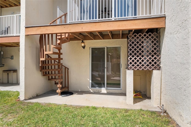 entrance to property featuring a patio area and stucco siding