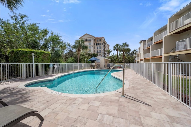 pool with a patio and fence