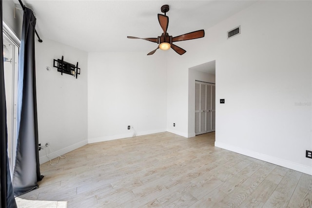 unfurnished room with ceiling fan, wood finished floors, visible vents, and baseboards