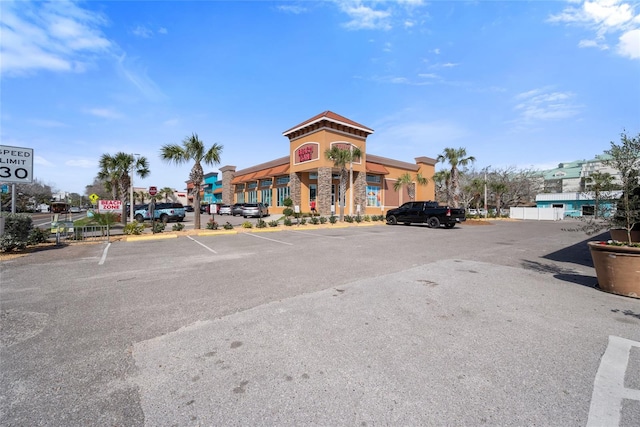 view of building exterior with uncovered parking