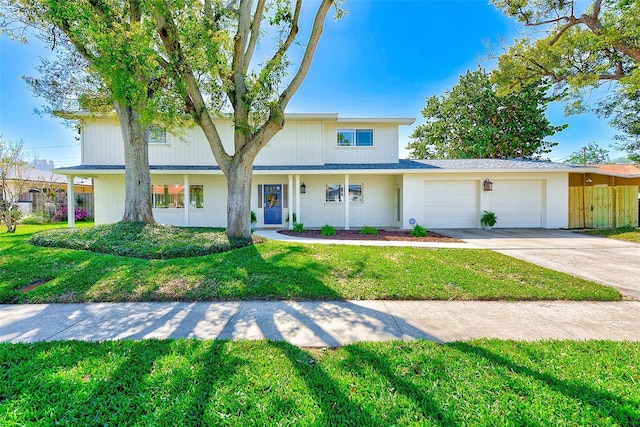 view of front of house with a front yard, concrete driveway, brick siding, and a garage