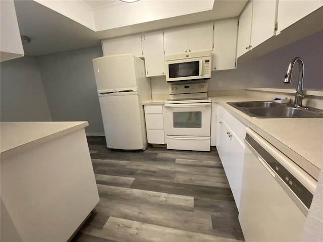 kitchen featuring light countertops, white appliances, white cabinetry, and a sink