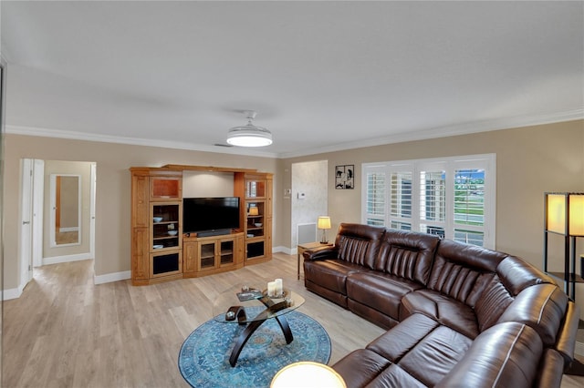 living room with ornamental molding, light wood-style flooring, and baseboards