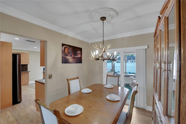 dining room featuring light wood finished floors, baseboards, crown molding, and an inviting chandelier