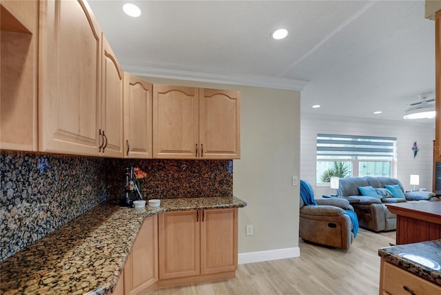 kitchen with light wood-style floors, light brown cabinets, decorative backsplash, and dark stone countertops