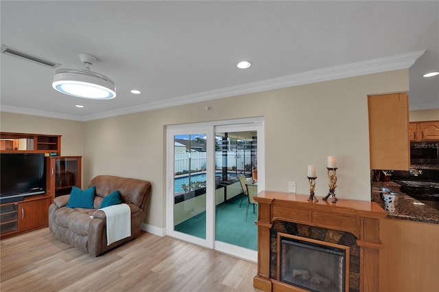 living area featuring recessed lighting, light wood-type flooring, visible vents, and crown molding