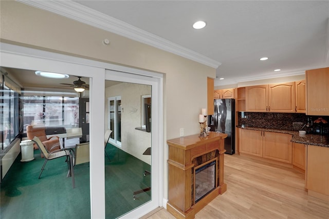 kitchen featuring light brown cabinets, light wood-style floors, decorative backsplash, black refrigerator with ice dispenser, and crown molding