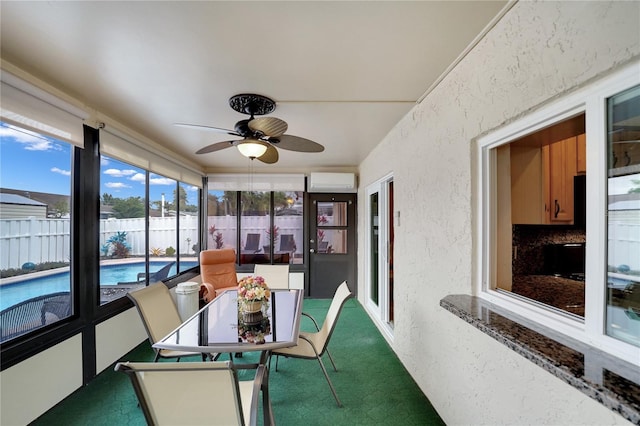 sunroom with an AC wall unit and ceiling fan