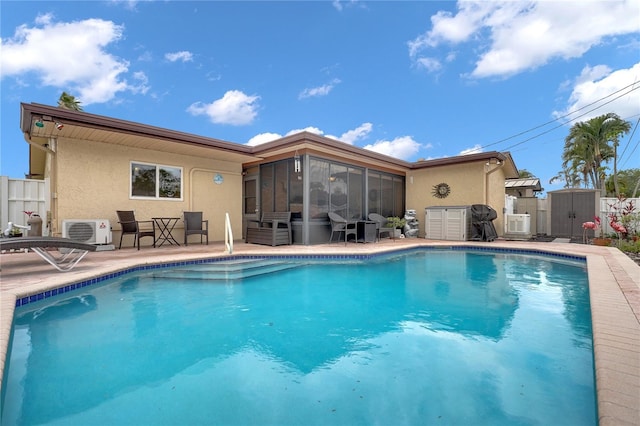 view of swimming pool with a fenced in pool, a sunroom, a patio area, a shed, and an outdoor structure