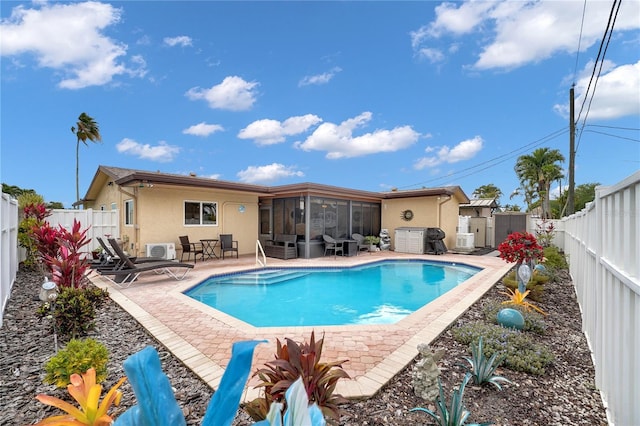 view of pool with a sunroom, a fenced backyard, a fenced in pool, and a patio