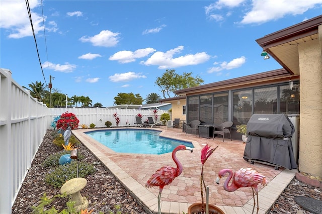 view of pool featuring a patio area, a fenced backyard, grilling area, and a sunroom