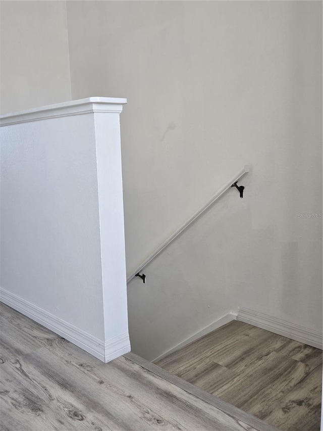 staircase featuring baseboards and wood finished floors