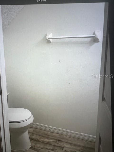 bathroom featuring toilet, baseboards, and wood finished floors