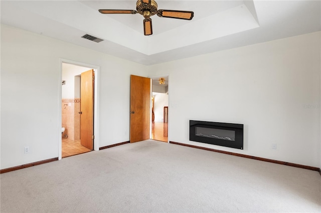 130 80th Ave NE, Saint Petersburg, FL 33702 - unfurnished living room with ceiling fan, visible vents, carpet floors, a raised ceiling, and baseboards