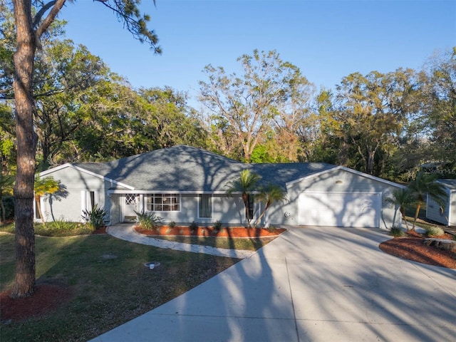 ranch-style home with an attached garage, driveway, and a front yard