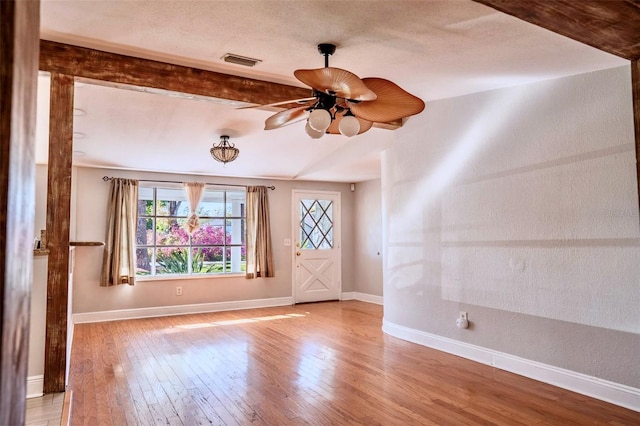 interior space featuring visible vents, baseboards, hardwood / wood-style floors, a textured ceiling, and a ceiling fan