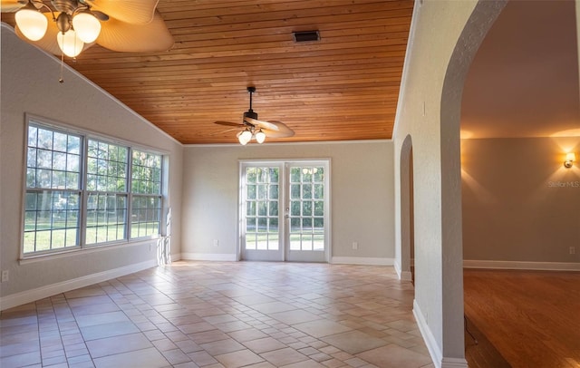 empty room featuring a ceiling fan, baseboards, lofted ceiling, arched walkways, and wood ceiling