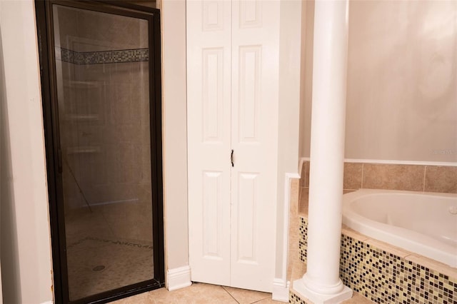 bathroom featuring tile patterned flooring, a garden tub, a stall shower, and a closet