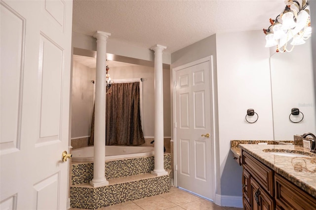 bathroom featuring vanity, decorative columns, a textured ceiling, tile patterned floors, and tiled shower / bath