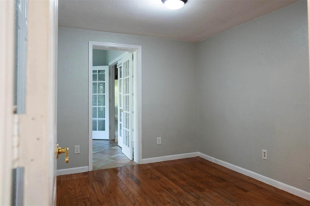 spare room featuring baseboards and wood finished floors