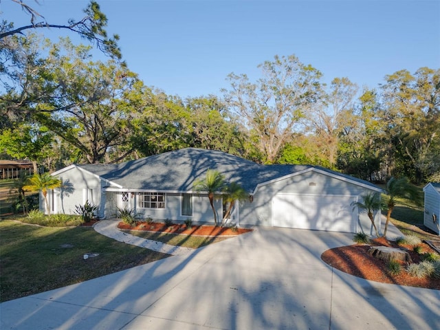 ranch-style home with an attached garage, concrete driveway, and a front yard