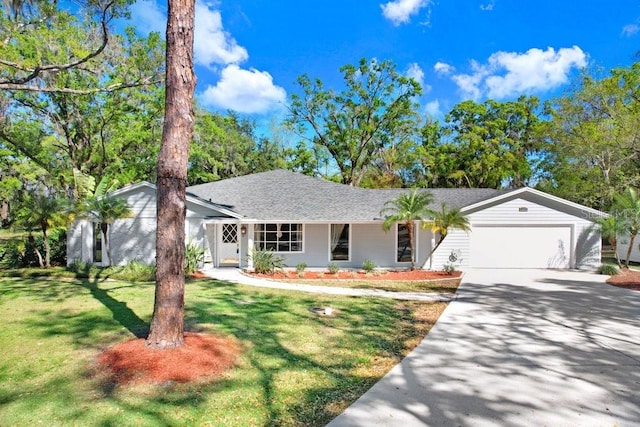 ranch-style home featuring a front lawn, concrete driveway, an attached garage, and roof with shingles