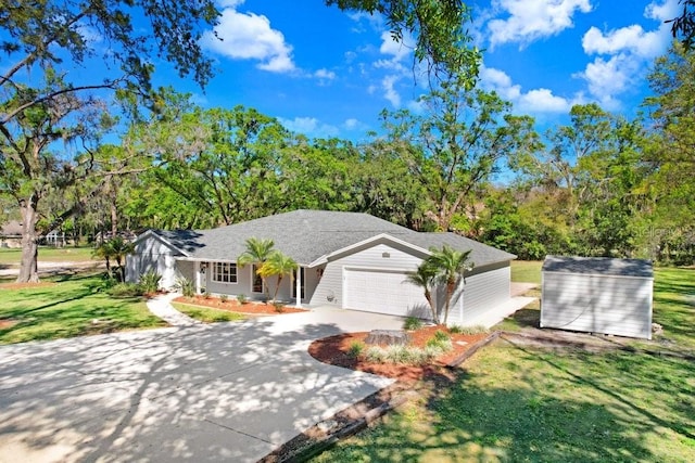 view of front facade featuring concrete driveway, a front yard, a garage, an outdoor structure, and a storage unit