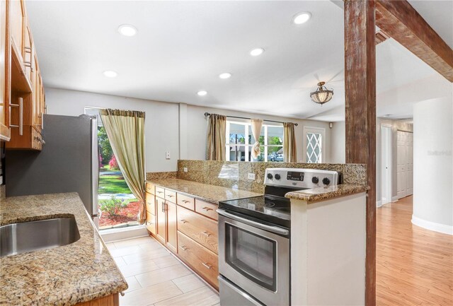 kitchen with light stone counters, stainless steel electric stove, recessed lighting, light wood-style floors, and a peninsula