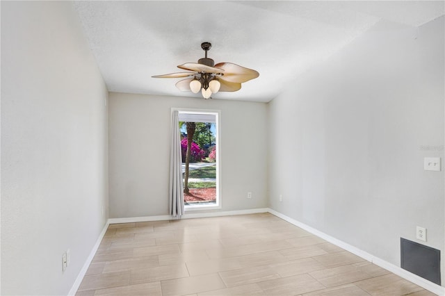spare room featuring baseboards and a ceiling fan