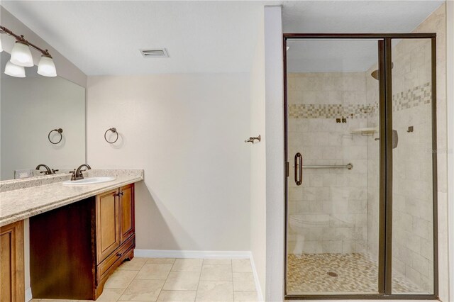 bathroom with vanity, baseboards, visible vents, a shower stall, and tile patterned floors