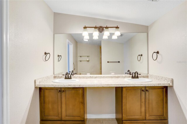 full bathroom with double vanity, tile patterned flooring, and a sink