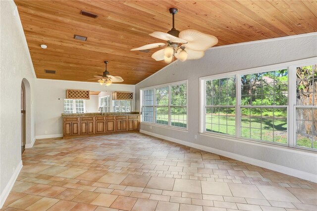 unfurnished sunroom featuring visible vents, lofted ceiling, wooden ceiling, arched walkways, and a ceiling fan