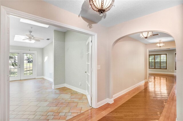 hallway featuring a chandelier, a healthy amount of sunlight, and baseboards