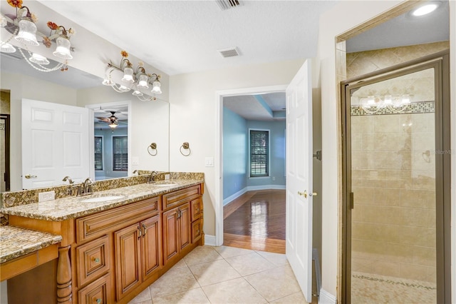 full bathroom with tile patterned floors, a stall shower, visible vents, and a sink