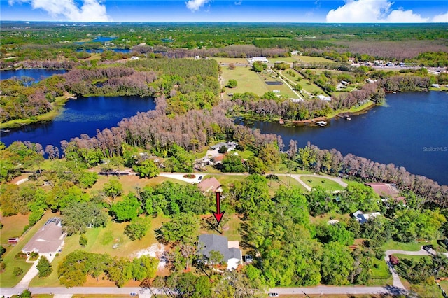 birds eye view of property with a view of trees and a water view