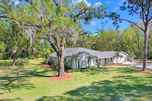 view of yard with driveway and a garage