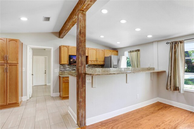 19531 Deer Lake Rd, Lutz, FL 33548 - kitchen featuring stainless steel refrigerator with ice dispenser, recessed lighting, light stone countertops, a kitchen breakfast bar, and tasteful backsplash