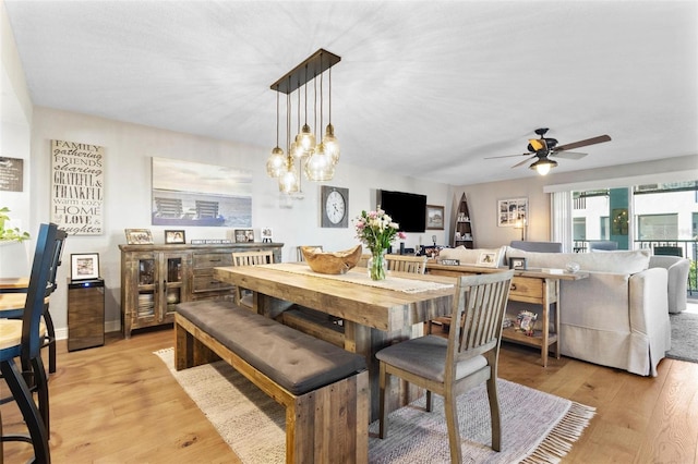 dining room with baseboards, ceiling fan, and light wood finished floors