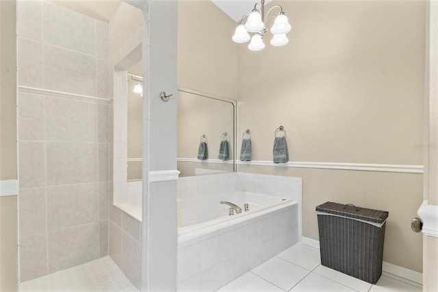 bathroom featuring an inviting chandelier, baseboards, a bath, and tile patterned floors