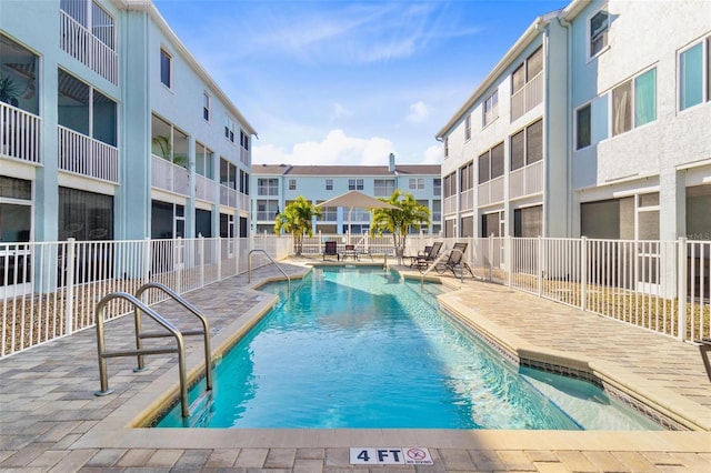 pool with a patio area and fence