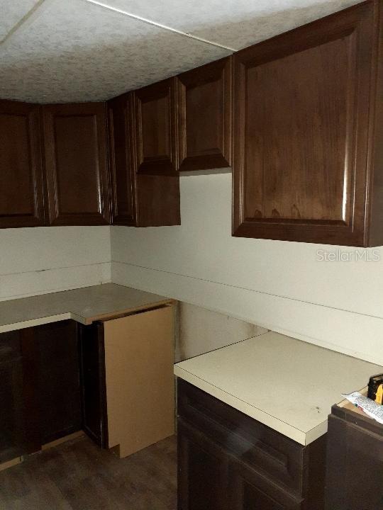 102 SE 6th Ave, Mulberry, FL 33860 - kitchen featuring dark brown cabinets and light countertops