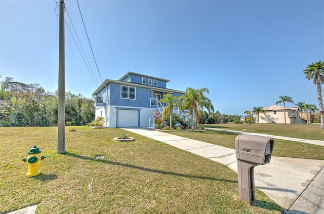 coastal home featuring a garage, driveway, and a front lawn